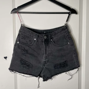 Svarta jeansshorts  - Svarta korta distressed shorts i storlek 34.