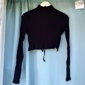 Stickad topp - Fin stickad topp från NA-KD. Ej använd, men köpt från en annan second hand. Öppen i ryggen med ett snöre, väldigt fint skick. 