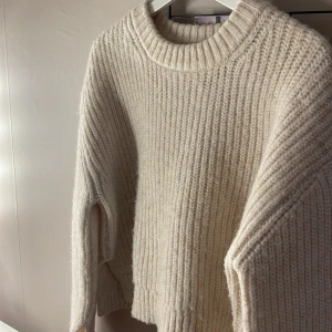 Beige stickad tröja  - Säljer denna beige stickade tröjan från Gina tricot med slits, använd fåtal gånger och säljs därför! Hör av dig vid frågor eller andra funderingar 💞