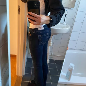 True Religion jeans i perfekt skick!  - Super snygga och trendiga True Religion Jeans med låg midja och slits! Storlek 25 och perfekt skick! 