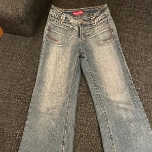Musketeer Bootcut Jeans - Super snygga Musketeer jeans i starkt material. Finns några defekter som två små fläckar och en större fläck. Fläckarna syns mindre i verkligheten. Dragkedjan vid gylfen är trasig men går att stänga med knapp. Passar 160/163cm (se midjemått)