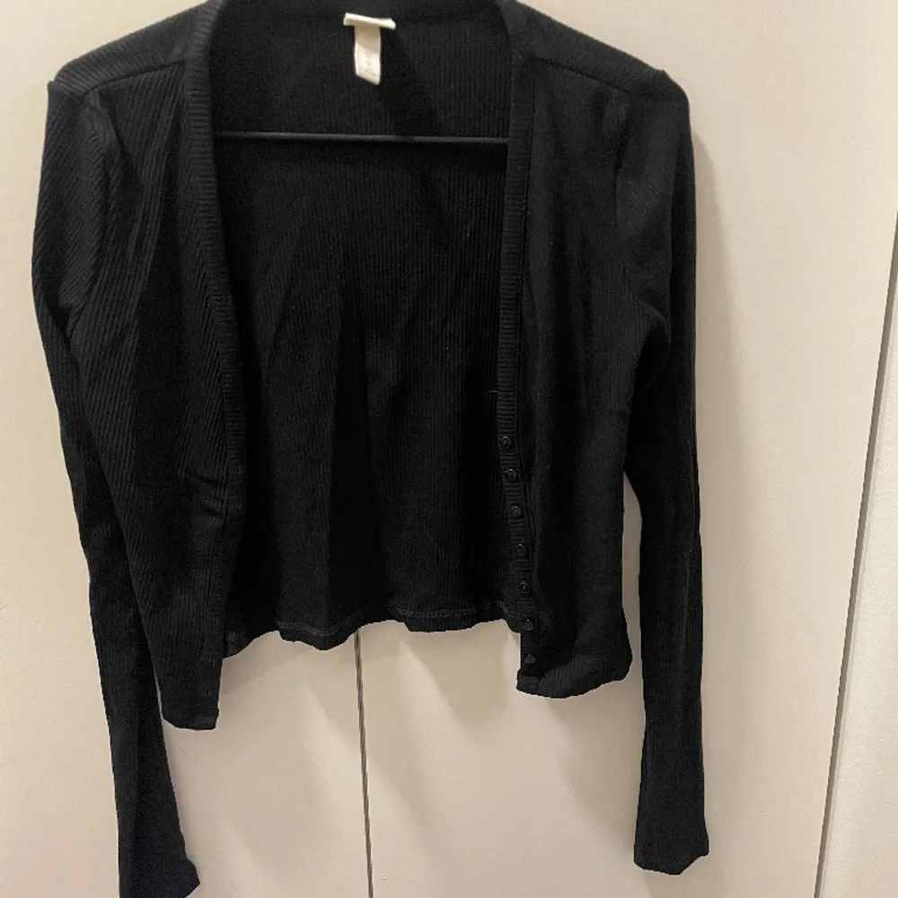 Svart kofta från h&m med knappar på framsidan i storlek XS. Använd ett fåtal gånger. Neuletakit & Villapaidat.