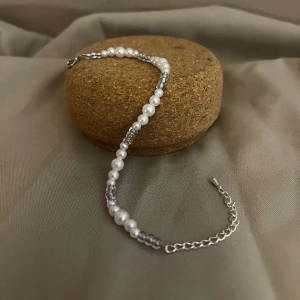 Armband - Izabella - Armbandet Izabelle består av olika storlekar av vita pärlor med silvriga små pärlor. Låset och kedjan är i silver.  Namn: Izabelle Längd: Hela 23 cm Pärlor 15,5 cm Pris: 99 kr