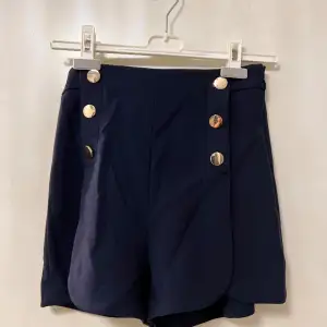 Marinblåa shorts med gulddetaljer från H&M. använt fåtal gånger.