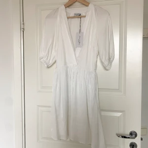 Vit klänning - Säljer denna klänningen från NAKD x Basma & Merna❤️‍🔥 helt oanvänd med prislapp kvar