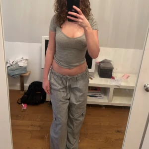 randiga byxor - säljer dessa byxor som ja köpte i barcelona, gråa med vita ränder, framfickor, sidofickor samt en ficka där bak, ganska tunt material, är 175 och de är långa på mig 