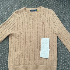 Ralph Lauren kabelstickad - Trendig Ralph Lauren tröja! Cond 8/10 använd 7-8 gånger. Inköpspris 1495, mitt pris 599. Skriv DM ifall du har några funderingar!