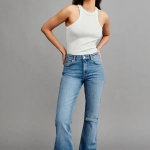 Blå jeans med hål - Supersnygga blå jeans från gina som inte längre kommer till användning. De är mid waist och har hål på högra knät. Skriv om du har några frågor💖