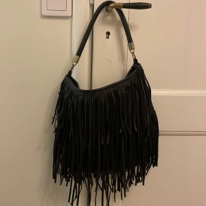Svart väska med fransar - Säljer denna superfina väskan med fransar från H&M.💗