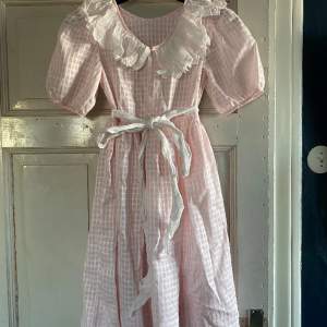 Gammaldags rosarutig klänning till barn. Hel och fin men bandet kan behöva strykas