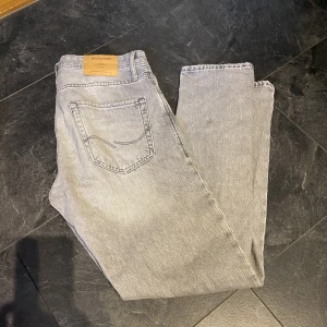 Herrjeans jack and jones🤍 - Gråa herrjeans från jack and jones i storlek 32/34. Modellen Loose/Chris Fint skick förutom en fläck på baksidan av ena benet som man kan se på bilden🤍 går säkert att få bort🙈