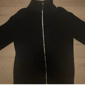 Svart Helzip - Säljer denna stilrena helzipen ifrån Brothers i nyskick, eftersom den inte används längre. Den har storleken L.