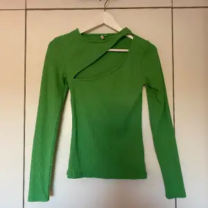 Grön tröja med utskuret mönster vid bröstet. Storlek S, men passar även som XS. Oanvänd.