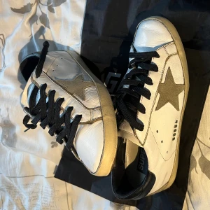 Golden goose skor - Säljer nu dessa Golden goose skor i storlek 39 med svarta snören. Riktigt sjysst skick, men en liten skada på hälen som nu ser i bilderna. Tillkommer skor och en dustbag🙌👏