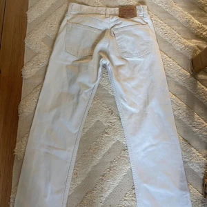 Vita Levis jeans  - Vintage levis 501 Står storlek 29/34 men måtten är: Midja 35cm  Längd 90cm   Översta knappen har åkt av samt en liten fläck på högra sidan där bak som jag ej testat om det går att få bort (se bilder) 
