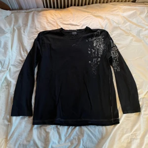 drainer tröja - svart långärmad tshirt med ett coolt tryck på axeln som jag köpte second hand. Skit snygg, men använder den ej längre. Ställ gärna mer frågor! 