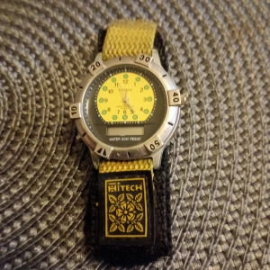 Herr klocka Hitech 50 water resistant. - Herr klocka Hitech Water resist 50 m.med kardborreband.nytt batteri alt mekanik 