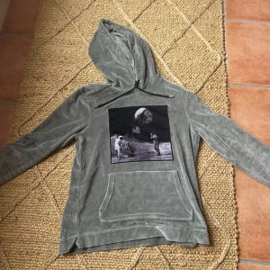Grå hoodie från Limitato - En grå limiterad hoodie från Limitato med ett tryck av en astronaut och en man på månen. Nypris 3500kr mitt pris 1999kr. Mycket bra skick i storlek S. Hoodien har långa ärmar och en ficka framtill. Materialet består av 80% bomull och 20% polyester med en innerfoder av 100% merceriserad bomull.