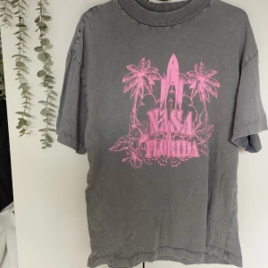 Oversized T-shirt med tryck - En grå oversized T-shirt med neon rosa tryck. Från H&M Storlek XS. 