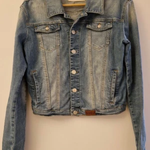 Svea jeansjacka strl M - Jeansjacka i märket Svea.Storlek M,liten i passform.Kort längd.Fint skick.
