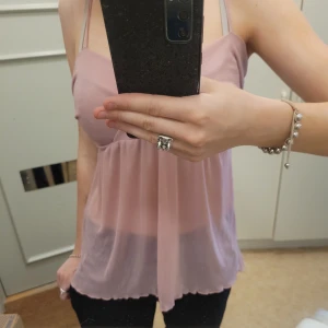 Rosa linne🎀💓 - Ursnyggt rosa linne/topp i ett lite genomskinligt material🔥🔥🔥 det är rätt urringad så skriv privat för fler bilder! Passar perfekt till fest !🎉 Passar storlek XS-M då ryggen är stretchig💕 säljer då den inte kommit till användning så skicket är 9/10🔥