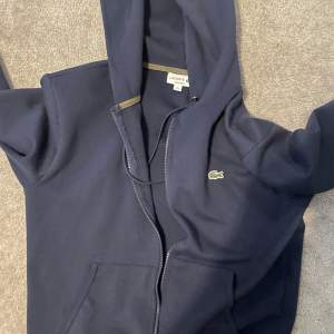 Extremt snygg lacoste zip hoodie, säljer för den inte används särskilt mycket. Äkta såklart, inga defekter eller liknande. 