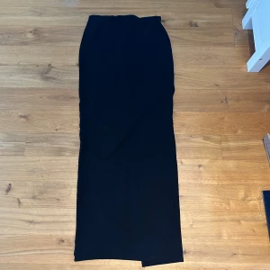 Långkjol  - Säljer denna långkjol ifrån nakd då den är för stor för mig. Super fin med slits där bak och skönt material. Midjemått är 64cm. 