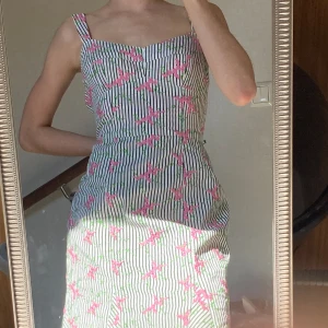 Sommar klänning - Säljer den drömigaste sommarklänningen! Randig klänning med rosa blom söm. Sitter så fint i passformen och är verkligen perfekt nu till sommaren!🌸 Har endast provat den så den är som ny!🌸