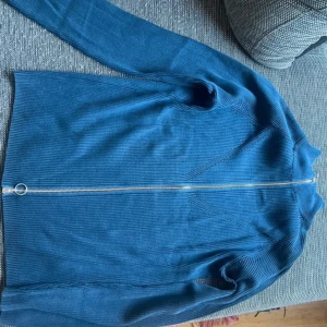 Blå topp med dragkedja  - Denna har inte används en ända gång utan bara legat paketerad i påsen då jag köpte 2 och skulle lämna tillbaka en men returtiden har gått ut. Inte ens testad på. Prislapp finns kvar!