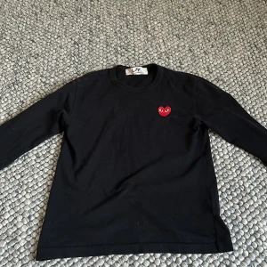 CDG tröja - Tjena, säljer denna snygga CDG tröja, använd ganska mycket men är fortfarande i ett väldigt bra skick, tröjan är hel och ren och är perfekt nu till sommaren då den är lite tunnare, mer som T shirt material.  Hör av er vid frågor eller funderingar!