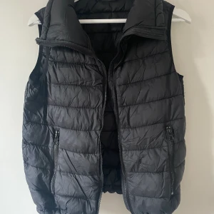 Svart väst  - Väst med fickor och dragsko nedtill om man vill göra den något tightare. Näst intill aldrig använd. 