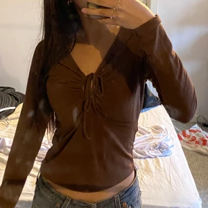 långärmad top bikbok - Den här fina bruna tröjan/toppen med knyt vid brösten från bikbok i storlek S. Materialet är inte för tjock så den är bra o ha till sommaren också🤎