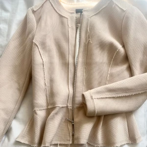 Volangjacka - Jättefin jacka/ kofta med volanger i en beige/ljusrosa färg. Perfekt inför sommaren!! Sitter som en S