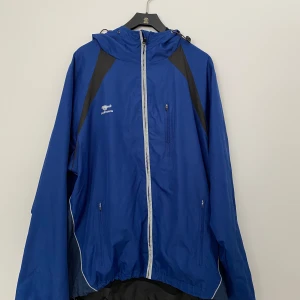Windbreaker // Bagheera - Klassisk windbreaker som kommer från märket Bagheera. Jackan är knappt använd men ena spänning snöret på höger sida är trasigt (se bild 5). Man kan fortfarande spänna åt på vänster sida däremot. Kan skickas på posten eller mötas upp i Gävle😇