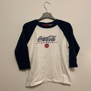 Coca-Cola tröja - Köpt i USA på coca-cola på 90-talet! Storleken säger L men skulle mer säga att den är mellan S-M!! Lite lätt gulnad längst ner (se bild) annars i fint skick!