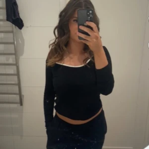 Basic tröja med detalj  - Vanligt svart tight tröja med en vit detalj vid u ringningen .