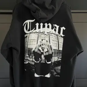 En Tupac hoodie med snyggaste trycket på ryggen. Stl M därmed sitter den oversized.