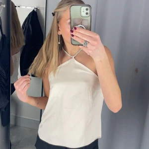 Topp - Super söt topp med öppen rygg, har ett silvrigt band runt nacken som man kan justera och är i skönt satin material 💗använd en gång, passar s - xs 