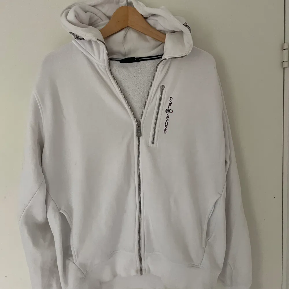 Sail racing zip i storlek M. Den är använd väldigt mycket samt att dragkedjan till fickan har lossnat men den går fortfarande att öppna. . Hoodies.