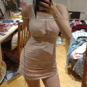 Supersöt kort klänning - En tight sittande väldigt bekväm kort klänning. Pastell rosa med vita blommor och spets! Supersöt verkligen🫶