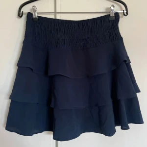 Volang kjol marinblå - Jag säljer en marinblå volangkjol från Vero Moda i storlek L. Kjolen är sparsamt använd och är i fint sick!  