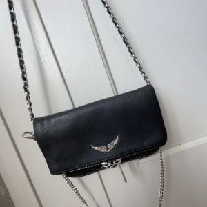 Rock nano väska Zadig Voltaire - Jättefin väska från Zadig Voltaire! Den är i mycket gott skick och är använd fåtal gånger, säljer den på grund av att jag precis har köpt en annan väska. Så den kommer därför inte till användning längre. Nypris ca 2800kr.