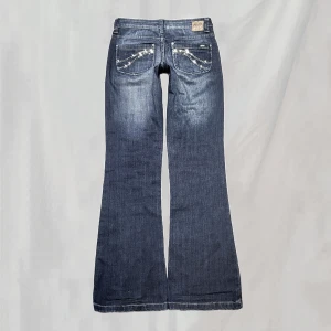 Lågmidjade jeans - Midja:ca71 innerben:80 Jeans vintage från diesel. Stenar på bakfickorna. Bootcutmodell. Storlek EU 32, passar en XS Några få stenar saknas. Ytterst smånötta enligt sista bild. Överlag mycket fint skick!!🤍