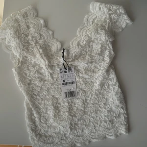 Spets topp - Säljer denna spelstopp från strandivarius!  Helt no, oanvänd med lappar kvar. Köpt på Zalando för någon månad sedan men inte kommit till användning. Säljer även en croppad t-Shirt till! 