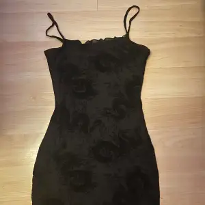 Svart klänning med drak mönster från H&M i storlek xs 