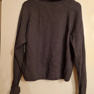 Stickad polotröja  - Stickad polotröja i bra skick, den är mörkgrå och är i storlek medium, det är knappt använd