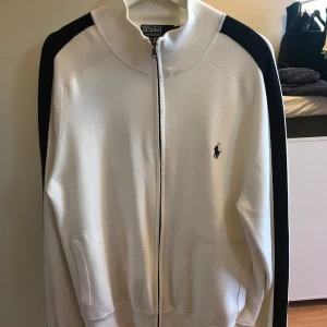 Vit Ralph lauren fullzip  - Tröjan är köpt i London på en retro klädesaffär som säljer äkta kläder och produkter. Storlek L men passar M. Om ni undrar något äre bara att höra av er:)