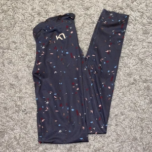 Träningstights från Kari Traa - Så söta och sköna tights! Använda men gott skick💕❣️Mörkgråa med mönster i rosa, blått och rött.