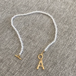 Ett halsband - Ett fint halsband med pärlor och initialen A