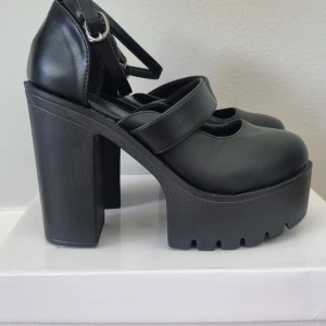 Klackskor - • Klackskor i svartsyntetläder • 10 cm hög klack • storlek 39 • Aldrig använda